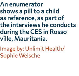 An enumerator shows a pill to a child as reference, as part of the interviews he conducts during the CES in Rosso vil...